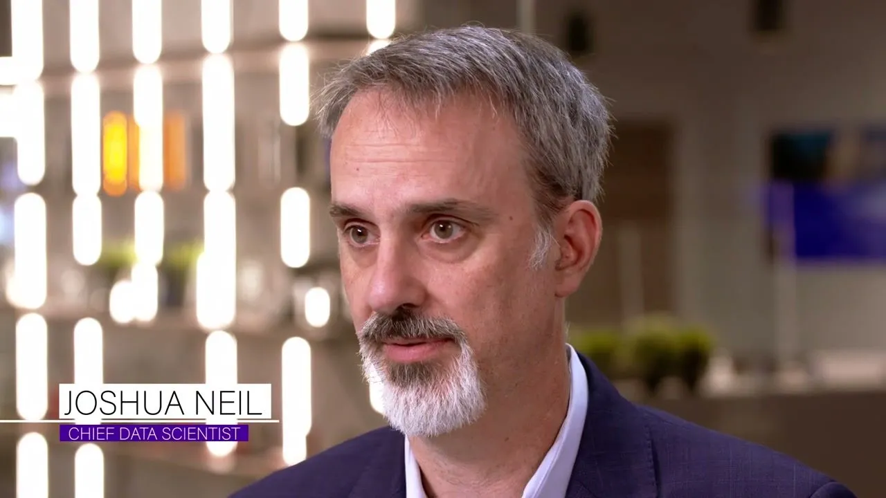 Joshua Neil, Securonix chief data scientist, interviewed in a glass-walled office